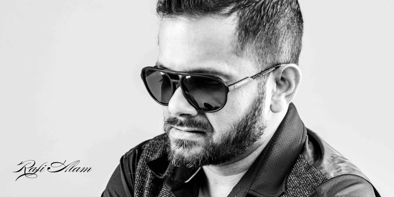 Portrait of Rafi Alam looking down wearing sunglasses