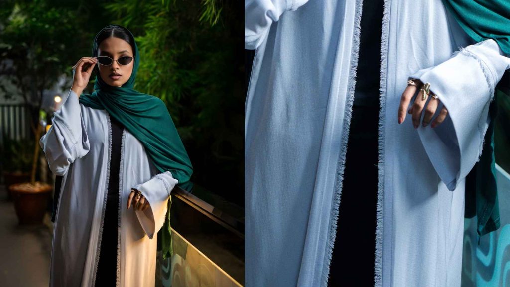 Zuhrah modern abaya banner showing a light blue open-front design with raw fringe detailing, styled for a chic urban modest look.