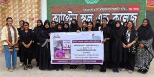 Students holding Safe Haven Pad Bank project banner.