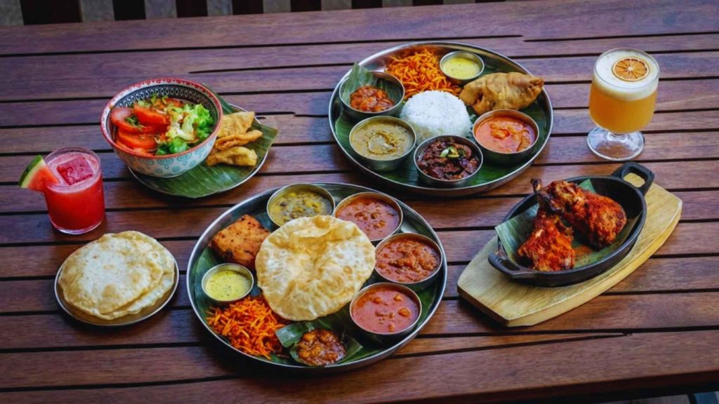 A massive Bengali Thali platter at Masalawala & Sons Brooklyn with rice, various curries, and traditional sides on a wooden table, ideal for authentic Indian dining enthusiasts.