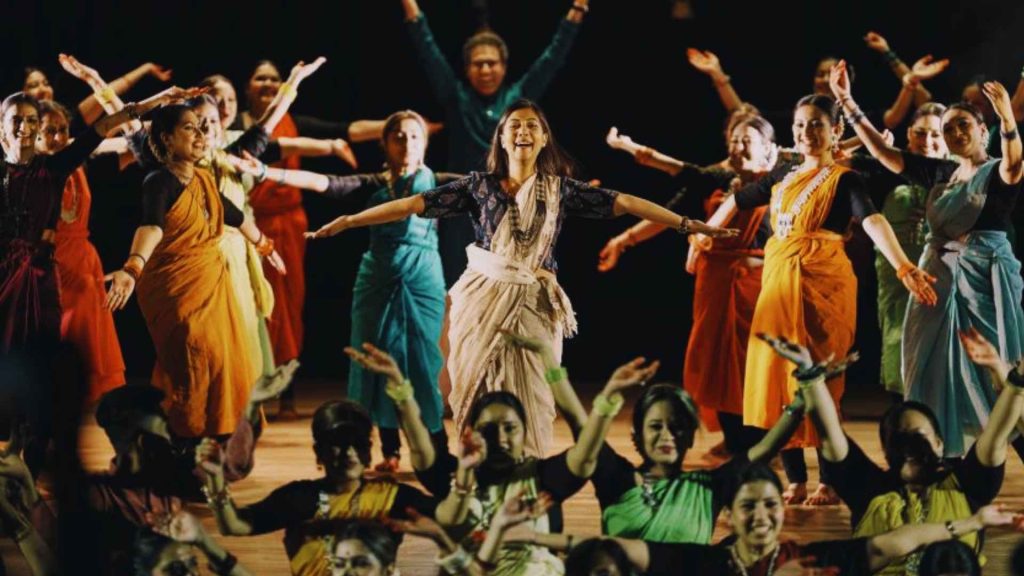 Arthy Ahmed performing on stage with a large group of dancers during the celebration of her Arthy Ahmed Ekushey Padak 2026 honor.