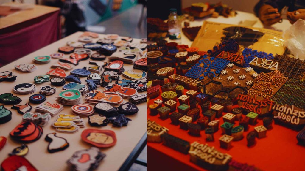 Split-screen close-up ad showing handmade character pins and intricate wooden block stamps, some marked "ARKA," for sale at the Arka Boishakh 1433 marketplace.