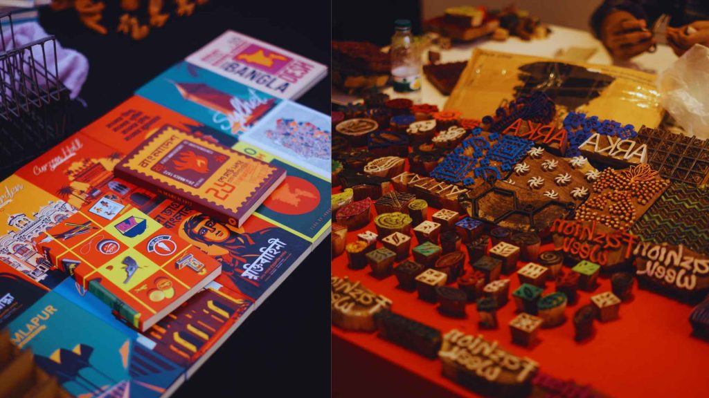 Close-up of a colorful graphic design book about Bangladesh and a collection of traditional wooden printing blocks, including one block clearly carved with 'Arka Boishakh 1433' on a red background.