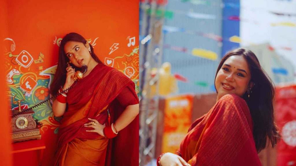 Amrin Tasnim Jaima at TINDS Social Dhaka wearing a stunning red and orange traditional saree, posing with a retro telephone against a creative graphic wall.
