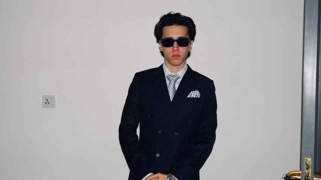 Music producer Umair dressed in a pinstripe suit and sunglasses, the creative force behind the production of the song 10 E 10.